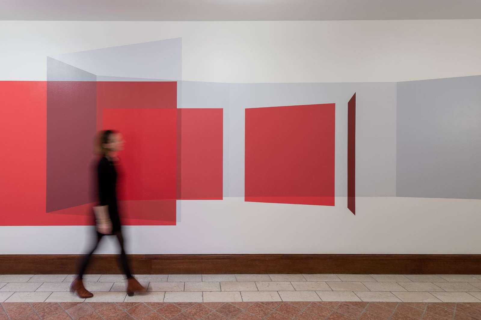 Woman walking in front of Kate Shepherd's wall painting at McNair Hall