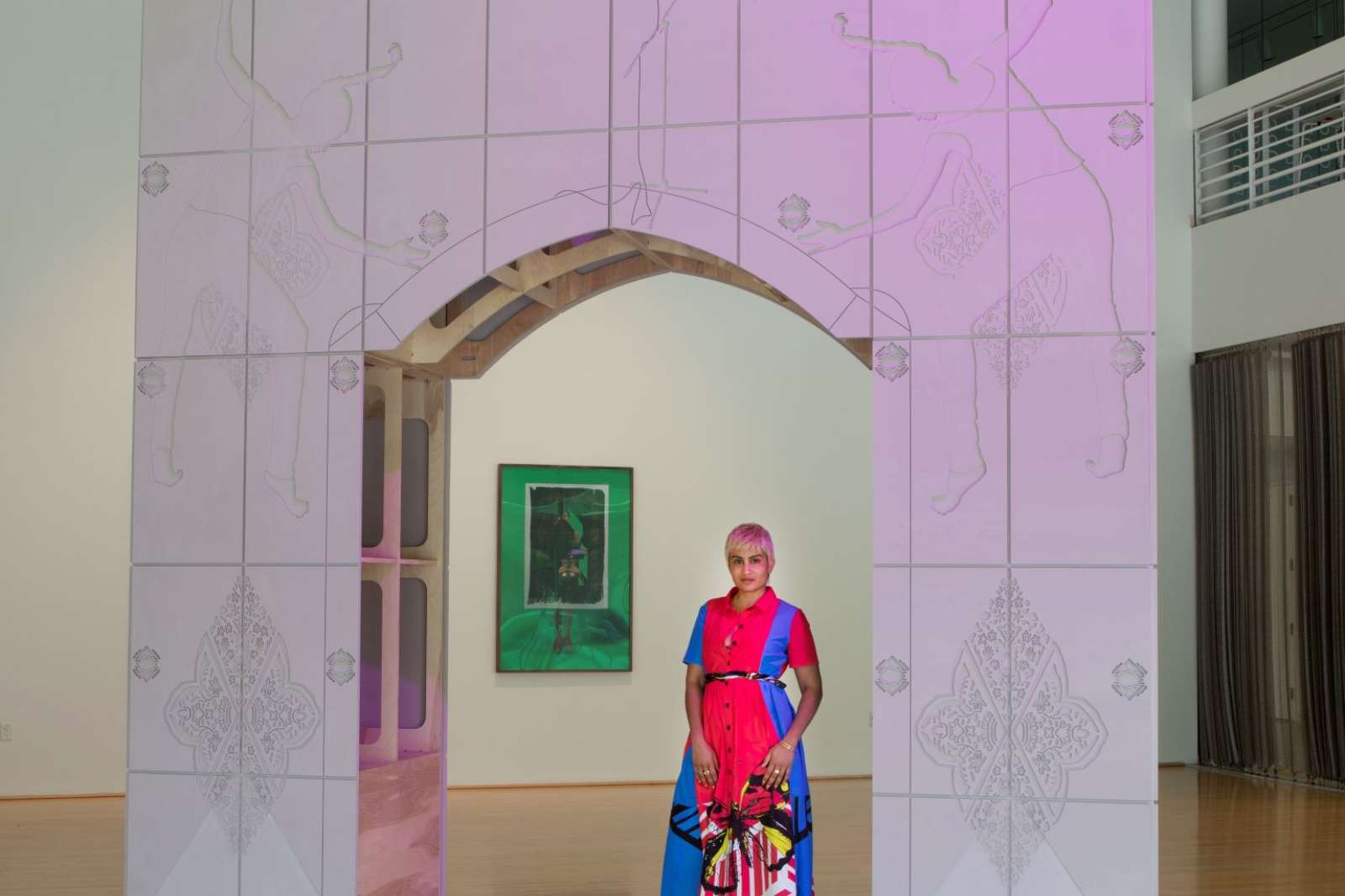 "Baseera Khan: Weight on History," installation view, "Painful Arc (Shoulder High)" with Baseera Khan. "Mosque Lamp and Prayer Carpet Green," from "Law of Antiquities" in background.  Photo by Geoff Winningham. 