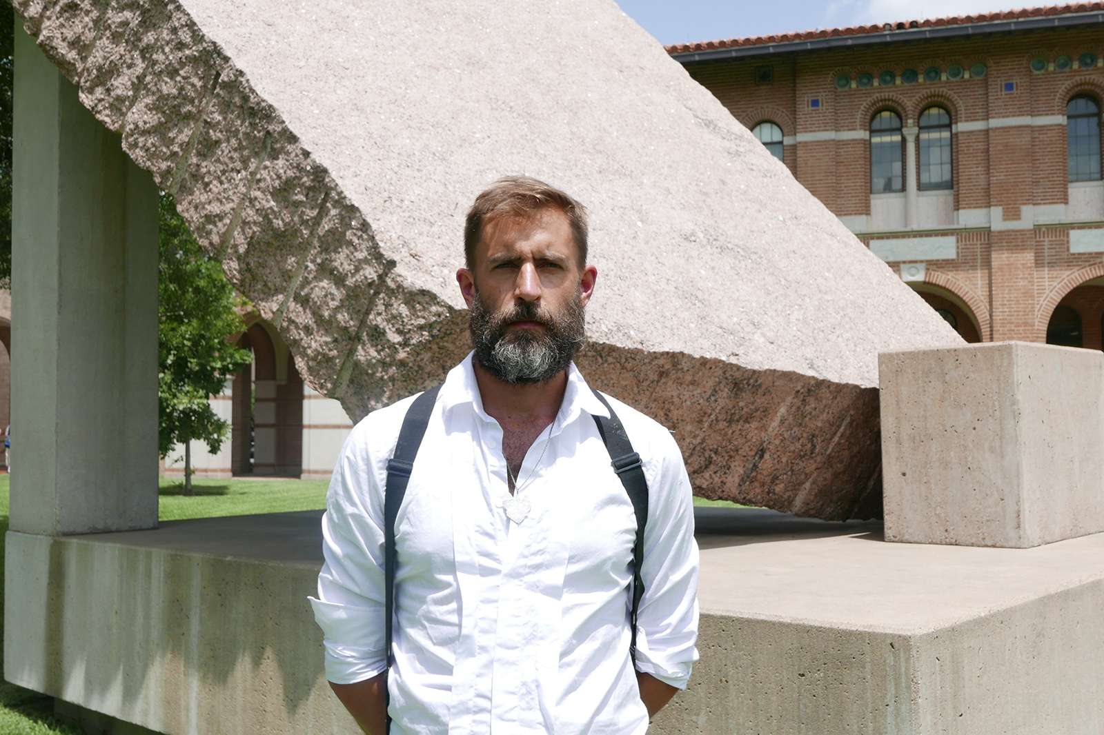 Artist Jarrod Beck with the 45° element of Michael Heizer’s massive granite sculpture 45°, 90°, 180° (1984) at Rice University. Photo courtesy Rice Public Art.