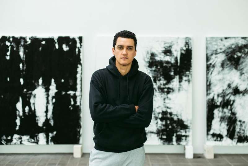Robin Rhode standing in front of his artwork