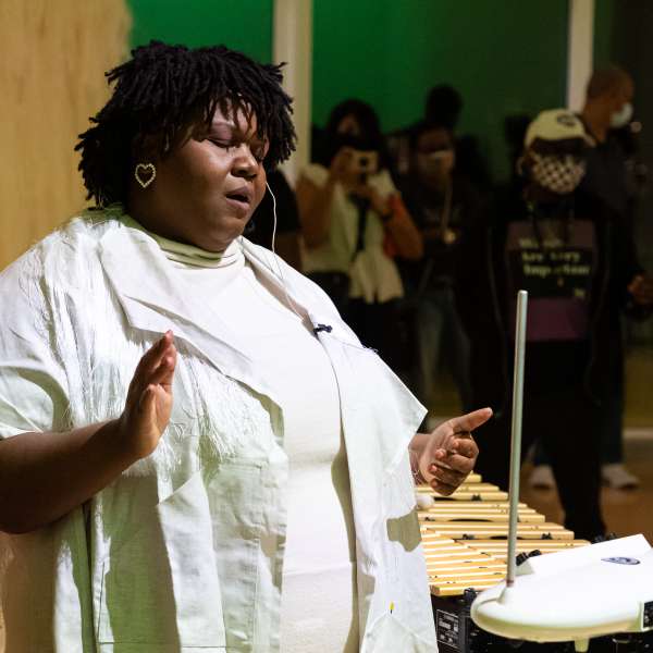 Lisa E. Harris performs for audience while wearing white