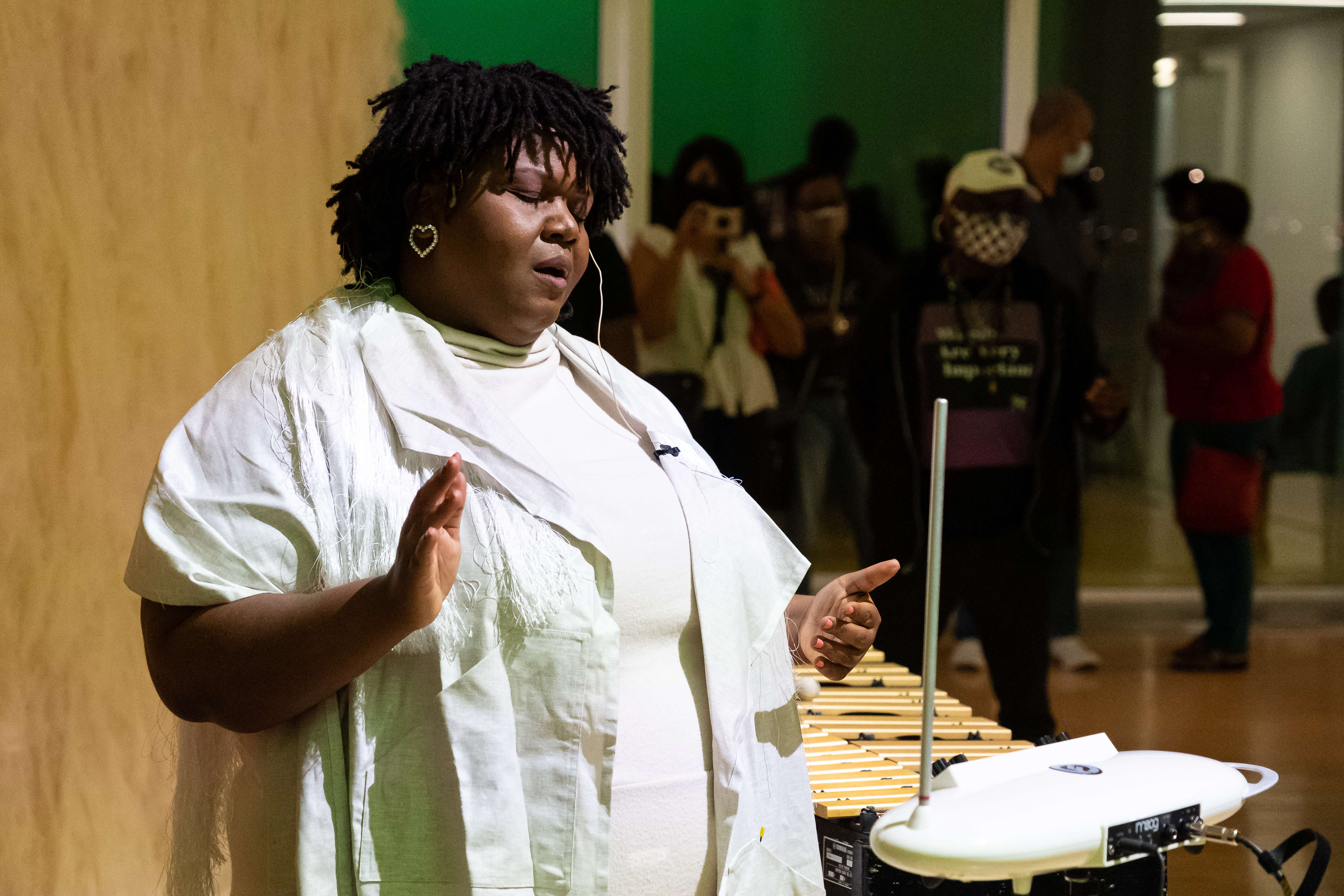 Lisa E. Harris performs for audience while wearing white